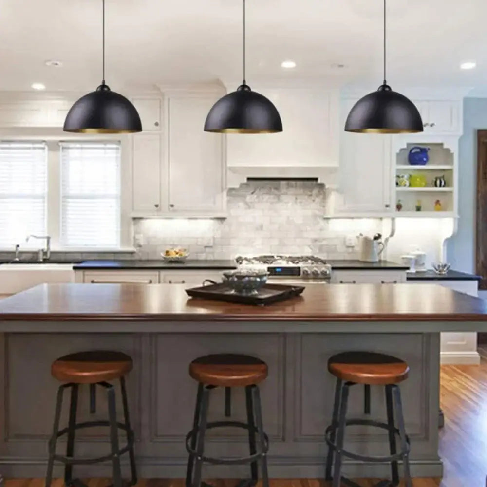 Three black metal cage pendant lights with gold interiors hang above a kitchen island decorbites black metal lamp