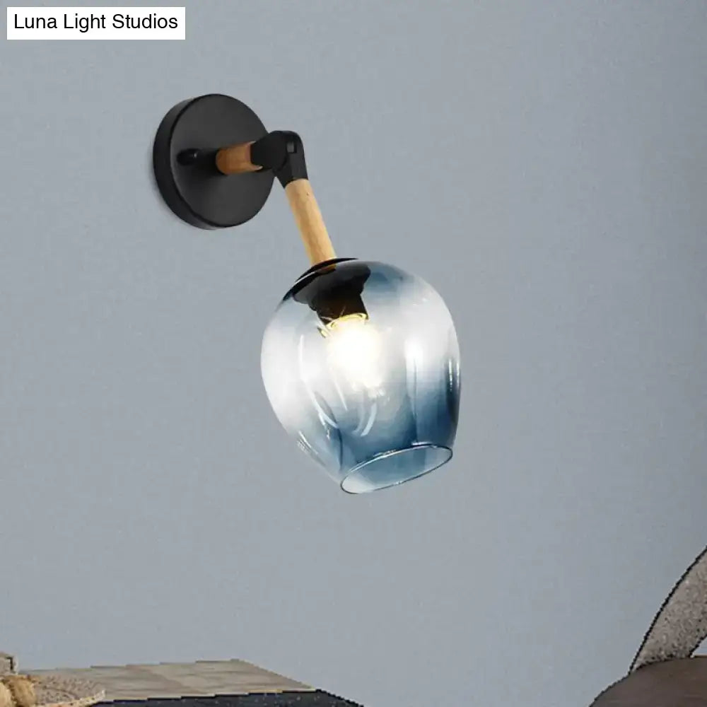 Industrial black and ocean blue wall sconce with blue gradient glass globe, black metal base, and wooden accent arm