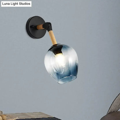 Industrial black and ocean blue wall sconce with blue gradient glass globe, black metal base, and wooden accent arm