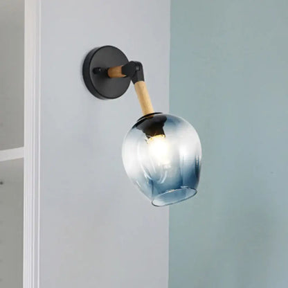 Industrial black and ocean blue wall sconce with blue gradient glass globe, black metal base, and wooden arm for bedroom lighting
