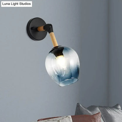 Industrial black and ocean blue wall sconce with blue gradient glass globe, wooden arm, and black metal bracket