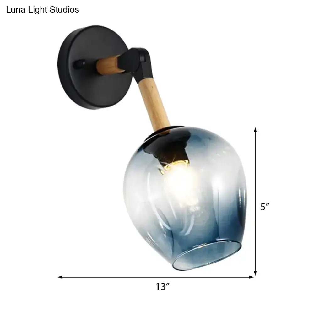 A sleek 5-inch industrial wall sconce with ocean blue gradient glass globe black metal base and wooden accent arm