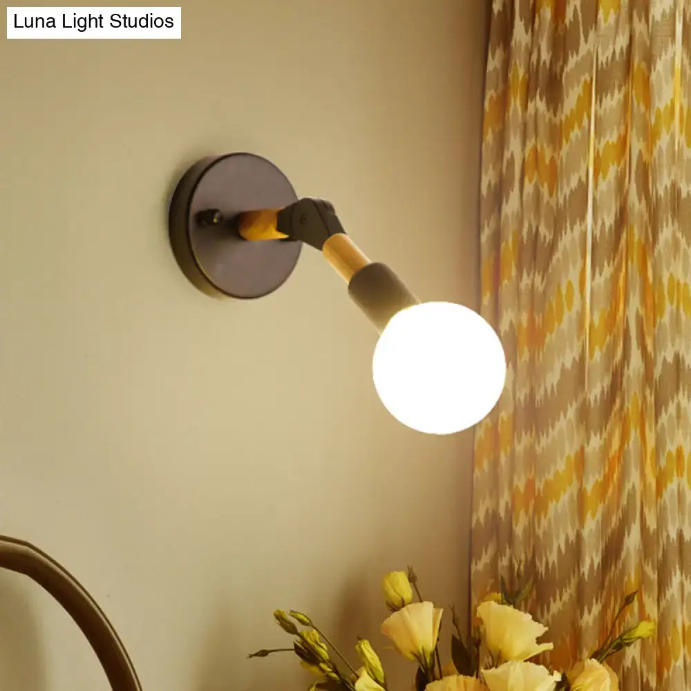 Industrial black and ocean blue wall sconce with matte black base, wood and metal arm, and glowing globe bulb