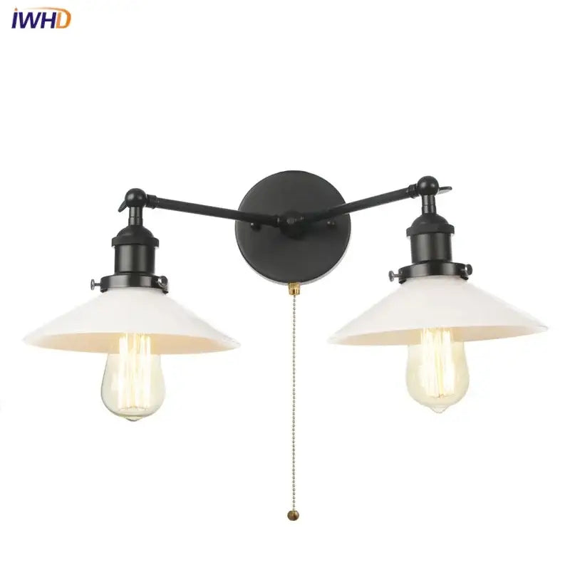 Industrial black and white wall light fixture featuring black wrought iron double-arm with white ceramic shades and Edison bulbs