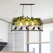 Industrial black metal bird-themed pendant light with warm e26 e27 bulb base and green ivy plant decoration