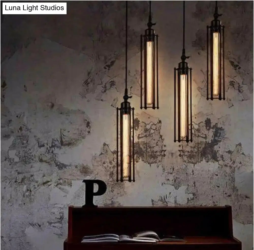 Industrial black and brass flute pendant light with black metal frame and glowing filament bulbs for kitchen island