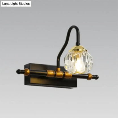 Industrial black and brass hexagon vanity wall lamp with crystal prisms featuring a vintage-style curved arm and warm glow