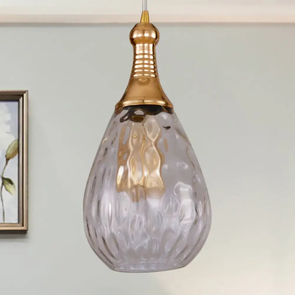 A teardrop ceiling light with textured gray glass shade and polished gold industrial black brass top from DecorBites Daisy