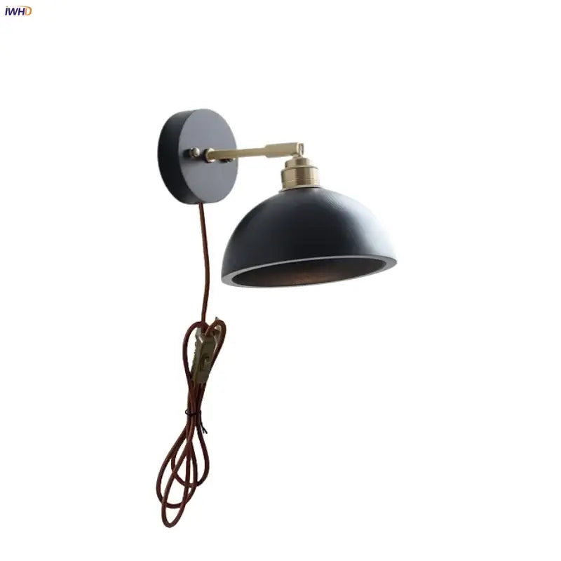 Industrial black and brass wall light fixture with matte finish and coiled brown cord for bedroom use