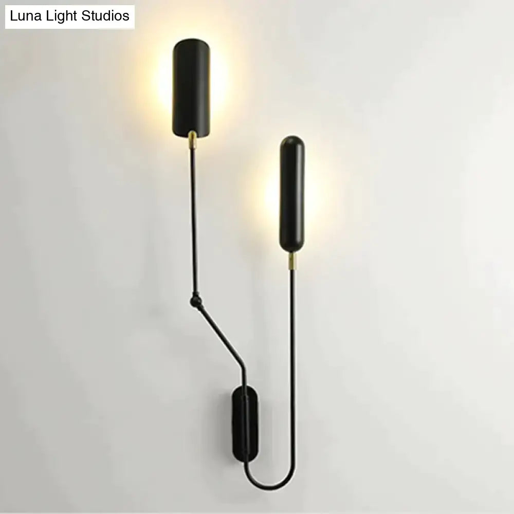 Black cylindrical emma industrial wall lamp with gold accents and adjustable arms for bedroom reading light