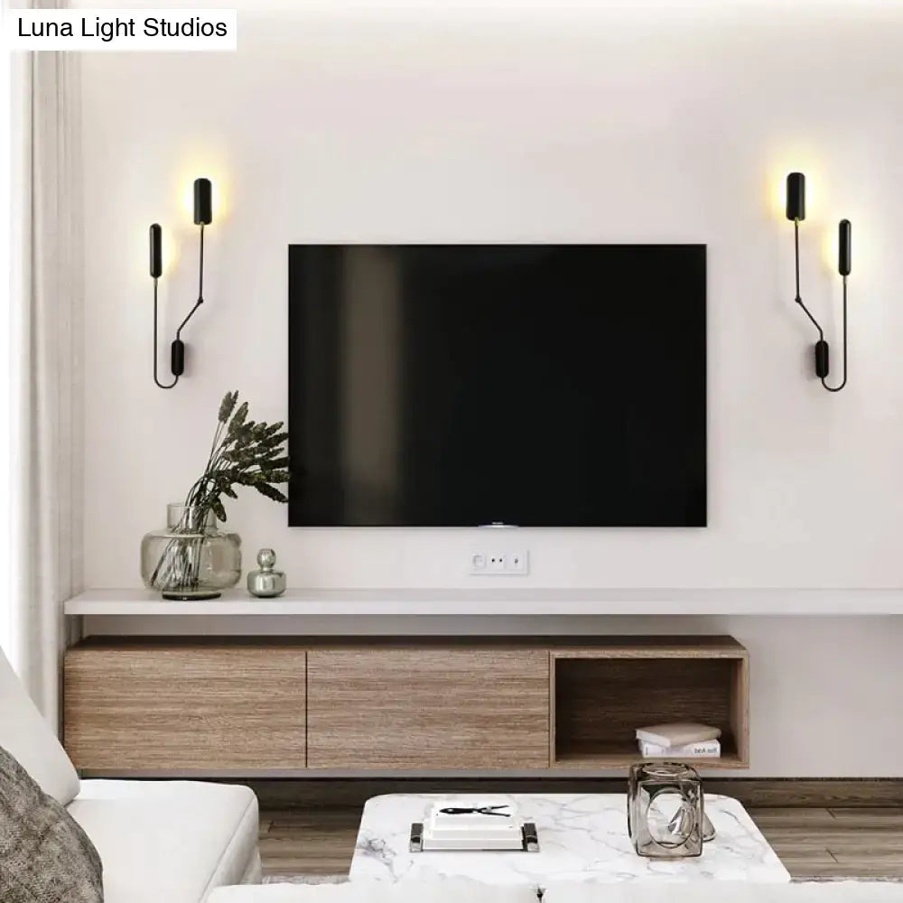 Black flat-screen television mounted on white wall with two black emma industrial wall lamps for bedroom reading light