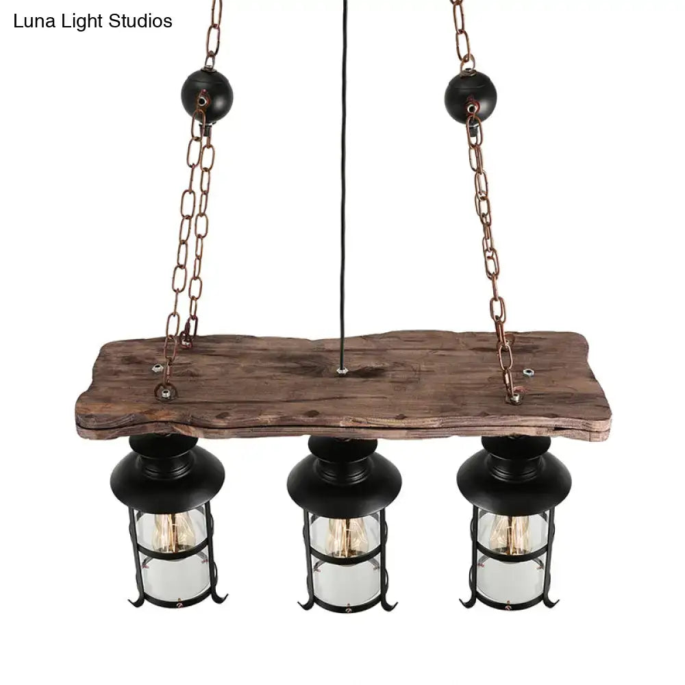 Decorbites™ industrial pendant light featuring three black cage lanterns with clear glass on a rustic wood plank hanging lamp