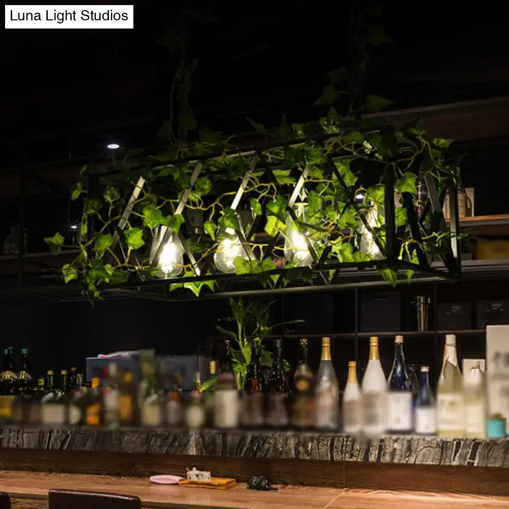 Industrial black metal cuboid plant island light fixture with exposed bulbs and hanging green ivy for dining room use