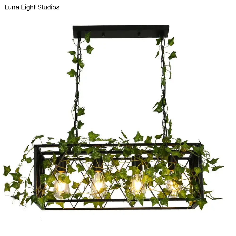 Black metal cuboid plant island light fixture with artificial green ivy and four exposed edison bulbs for dining room