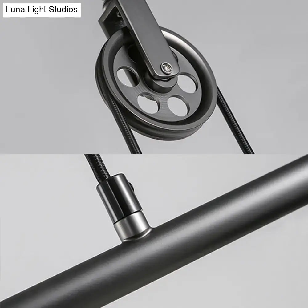 Black metal pulley with circular design and central screw attached to braided cable for DecorBites™ saucer foyer island ceiling light