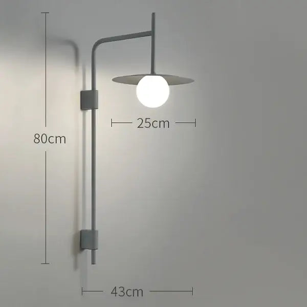 Modern gray metal wall lamp with a spherical frosted glass bulb and flat circular shade in industrial style wall design