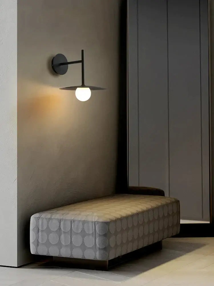 Modern black industrial minimalist style wall lamp with a sleek design and warm white globe bulb for bedroom use