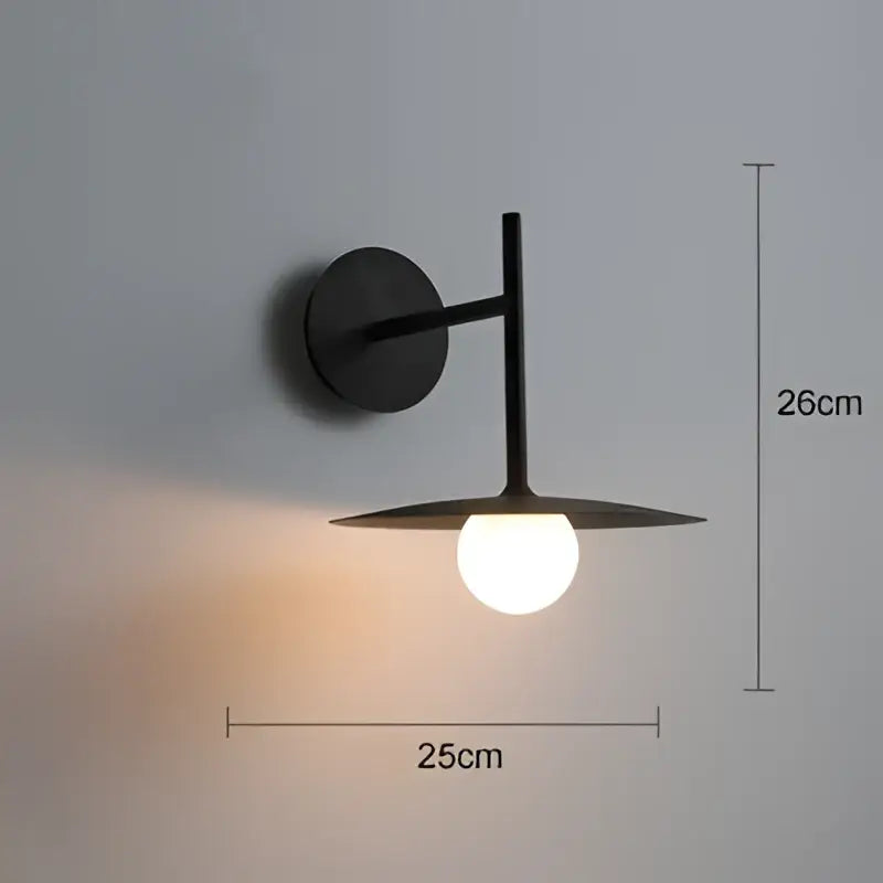 Industrial black minimalist wall lamp with a circular base and angular arm holding a frosted glass globe for style wall use