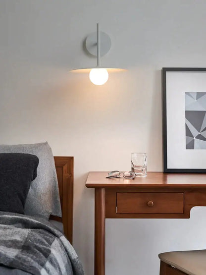 Industrial black minimalist wall lamp with a sleek white circular bulb providing warm glow for style wall use