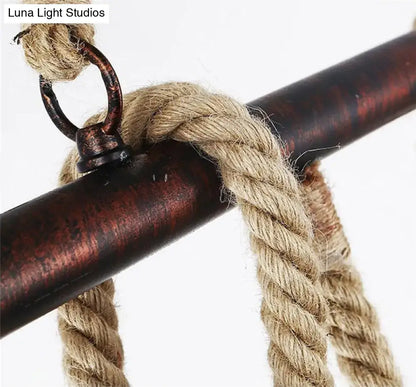 Thick beige braided rope with dark rustic metal ring for industrial black pipe and rope chandelier on linear restaurant island