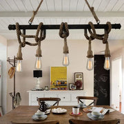 Industrial black pipe and rope chandelier with exposed filament bulbs for linear restaurant island lighting