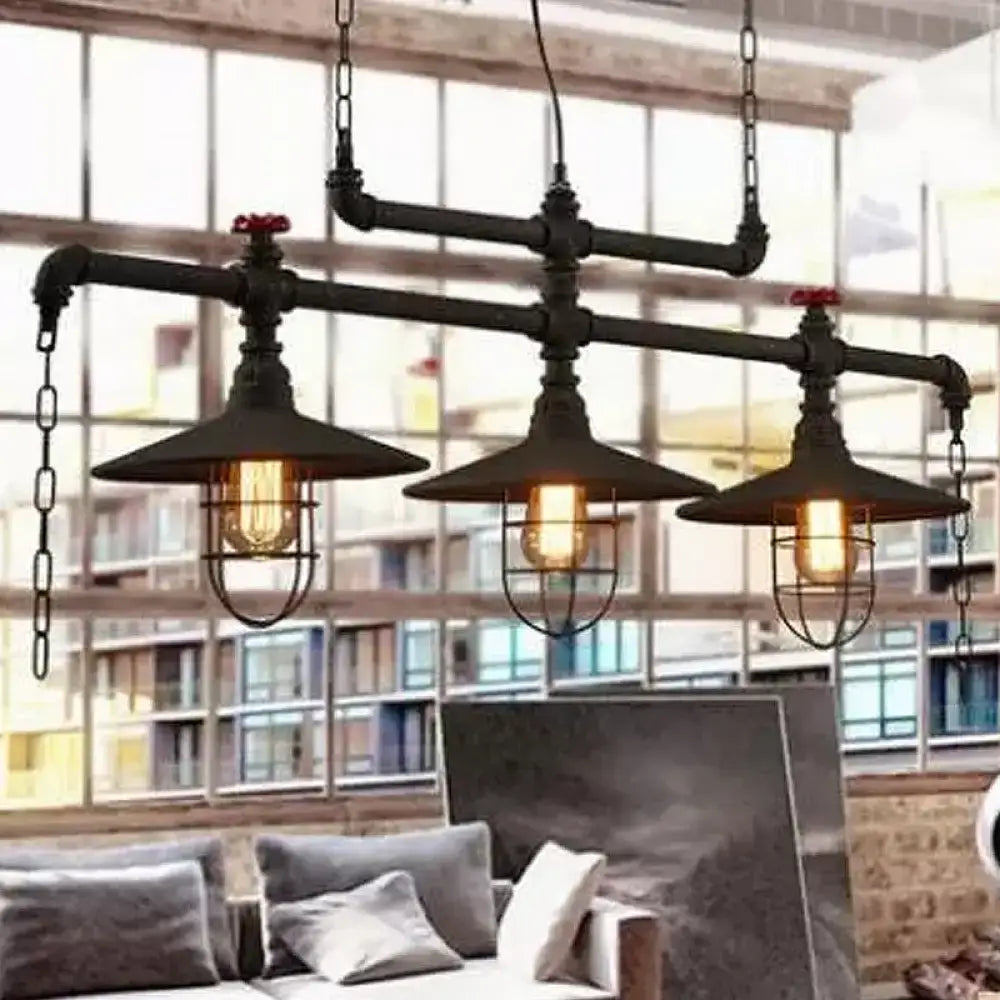 Industrial black pipe chandelier with three exposed filament bulbs and red valve caps for dining room lighting