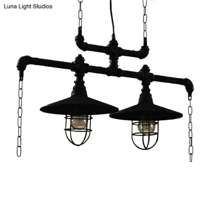Industrial black pipe chandelier with two exposed bulb fixtures and protective wire cages featuring red valve caps for dining rooms