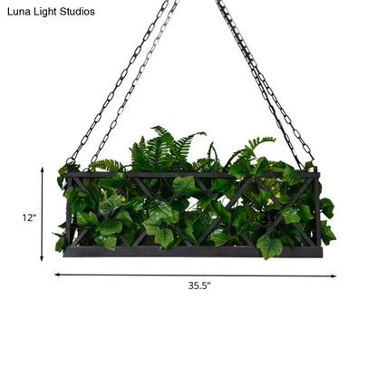Black metal hanging planter with lattice design filled with artificial ferns beside DecorBites™ black rectangular island ceiling light fixture