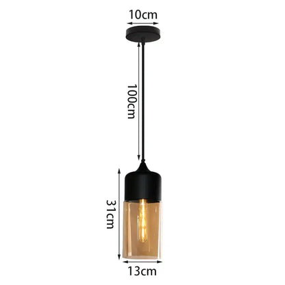 Black metal pendant light with cylindrical amber glass shade featuring exposed filament bulb for kitchen decor
