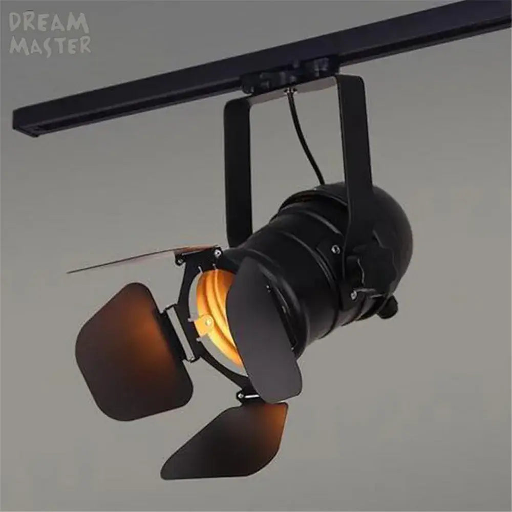 Black metal industrial spotlight rail light with adjustable barn doors and warm amber light for commercial store lighting