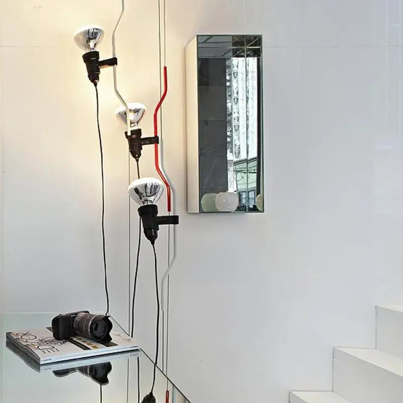 Industrial black wrought iron adjustable pendant lamp with three silver reflector bulbs on curved pipe structure
