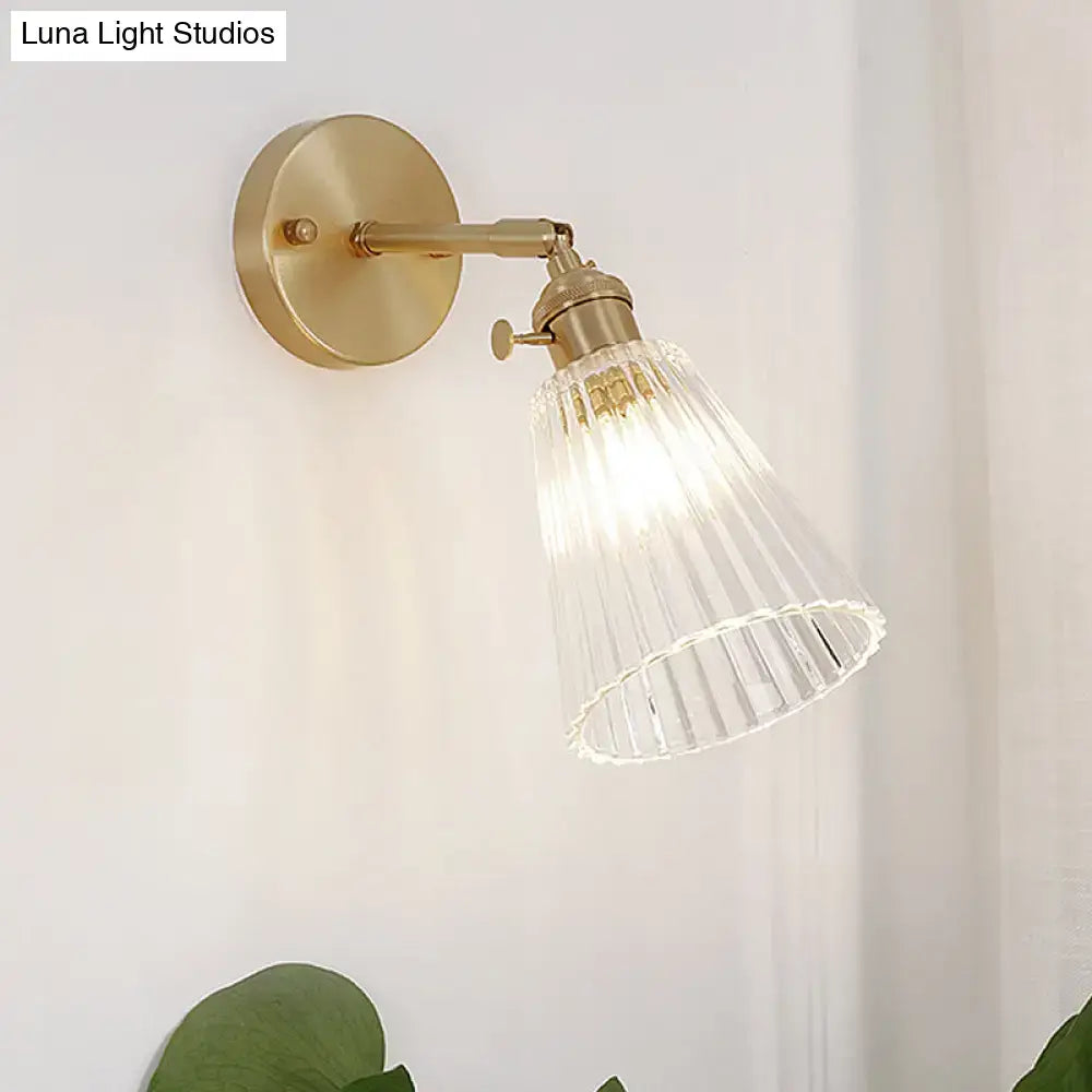 Decorbites clear textured glass wall sconce with brass accents featuring a clear textured glass ribbed shade for dining rooms