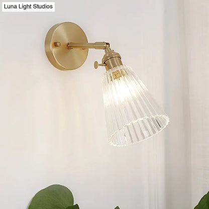 Decorbites clear textured glass wall sconce with brass accents featuring a clear textured glass ribbed shade for dining rooms