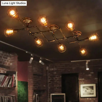 Industrial brass intersecting piping ceiling light with dark metal frame wire cages and warm amber bulbs for dining room