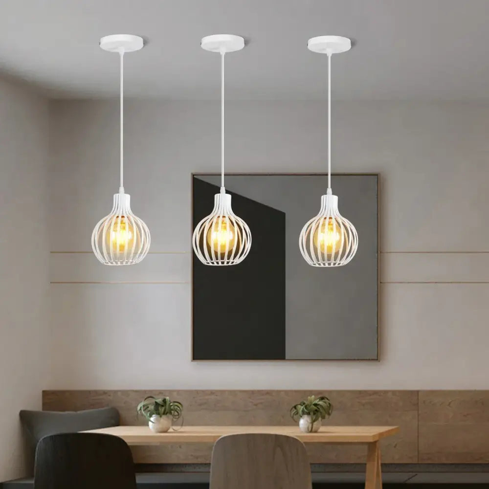 Three white industrial cage led pendant lights with wire design hang above wooden table for decorbites decor