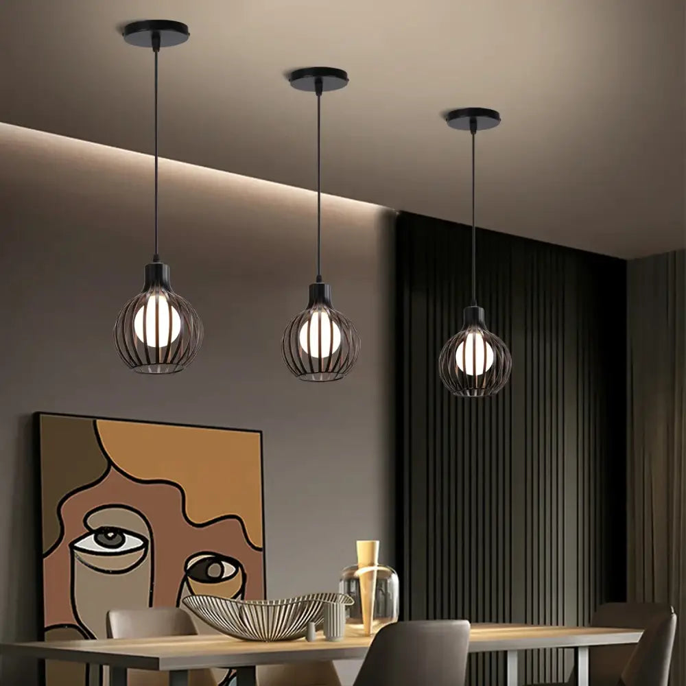 Three black wrought iron industrial cage led pendant lights hang from the ceiling for decorbites industrial cage decor