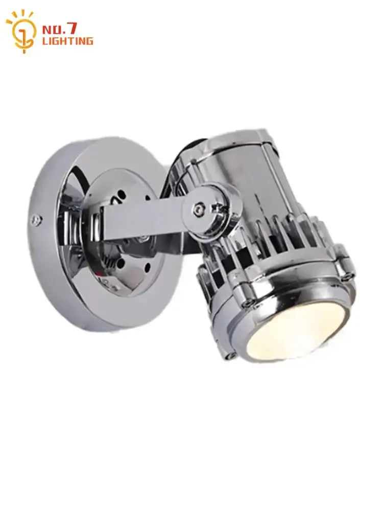 Industrial chrome adjustable wall lamp with vintage style spotlight head and visible cooling fins for bedroom use