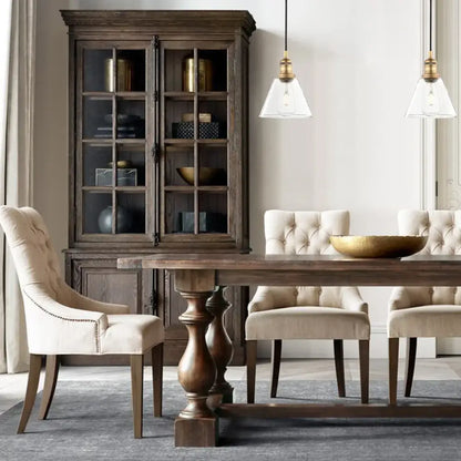 Dark wood dining table with turned legs and central pedestal base featuring industrial clear glass funnel flared pendant light decorbites