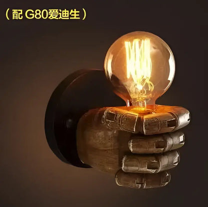 A vintage wall lamp with an industrial fist resin hand base holding an illuminated g80 edison bulb decorbites industrial fist