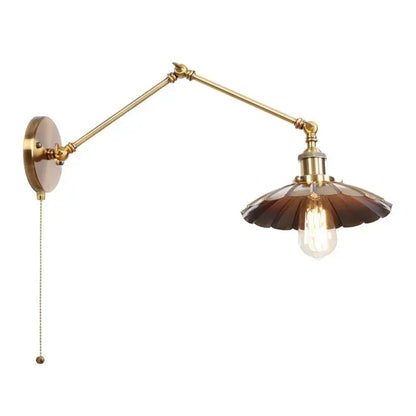 Brass adjustable wall lamp with dark brown fluted glass shade and exposed filament bulb featuring a pull chain switch