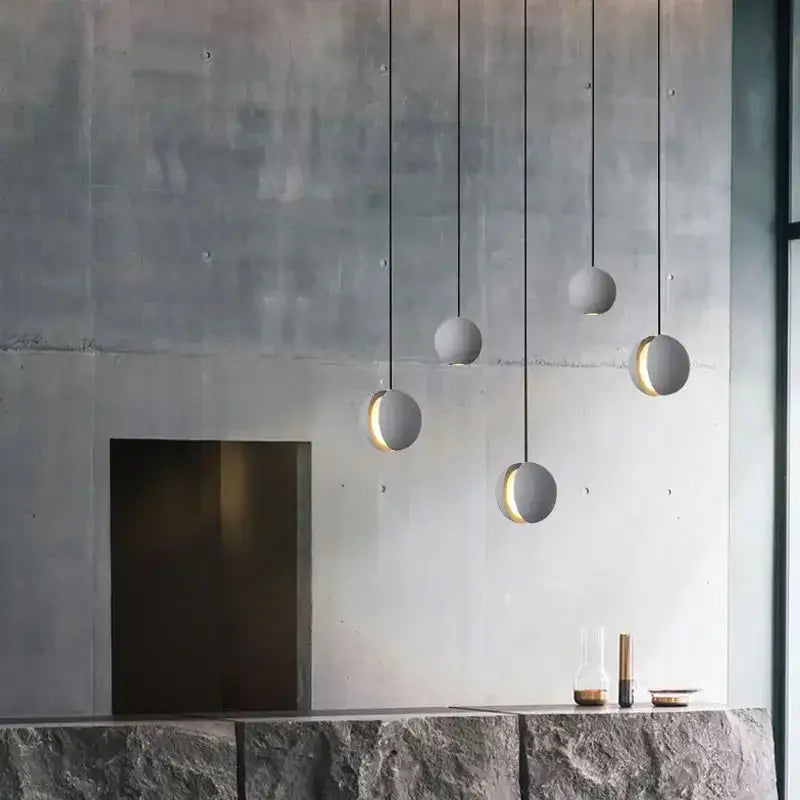 Minimalist industrial gray and gold decorbites cement pendant light with matte concrete finish and warm inner glow