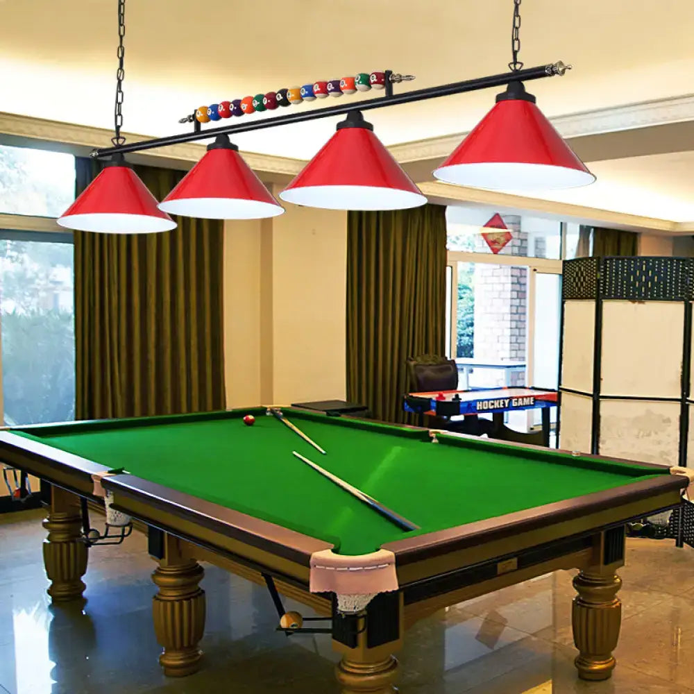 Red conical metal billiard lamp with white interiors hanging above green pool table as country club island light