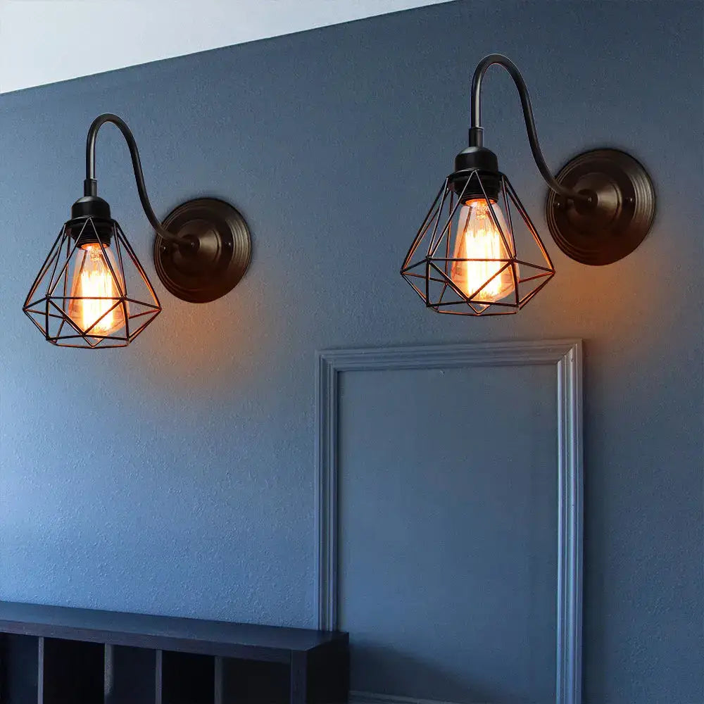 Industrial iron wall sconce black cage light featuring geometric wire design and glowing edison bulbs by decorbites
