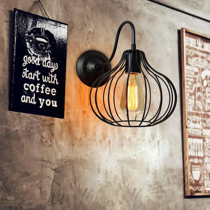 Black wrought iron wall sconce with cage design and exposed edison bulb from decorbites industrial iron wall collection
