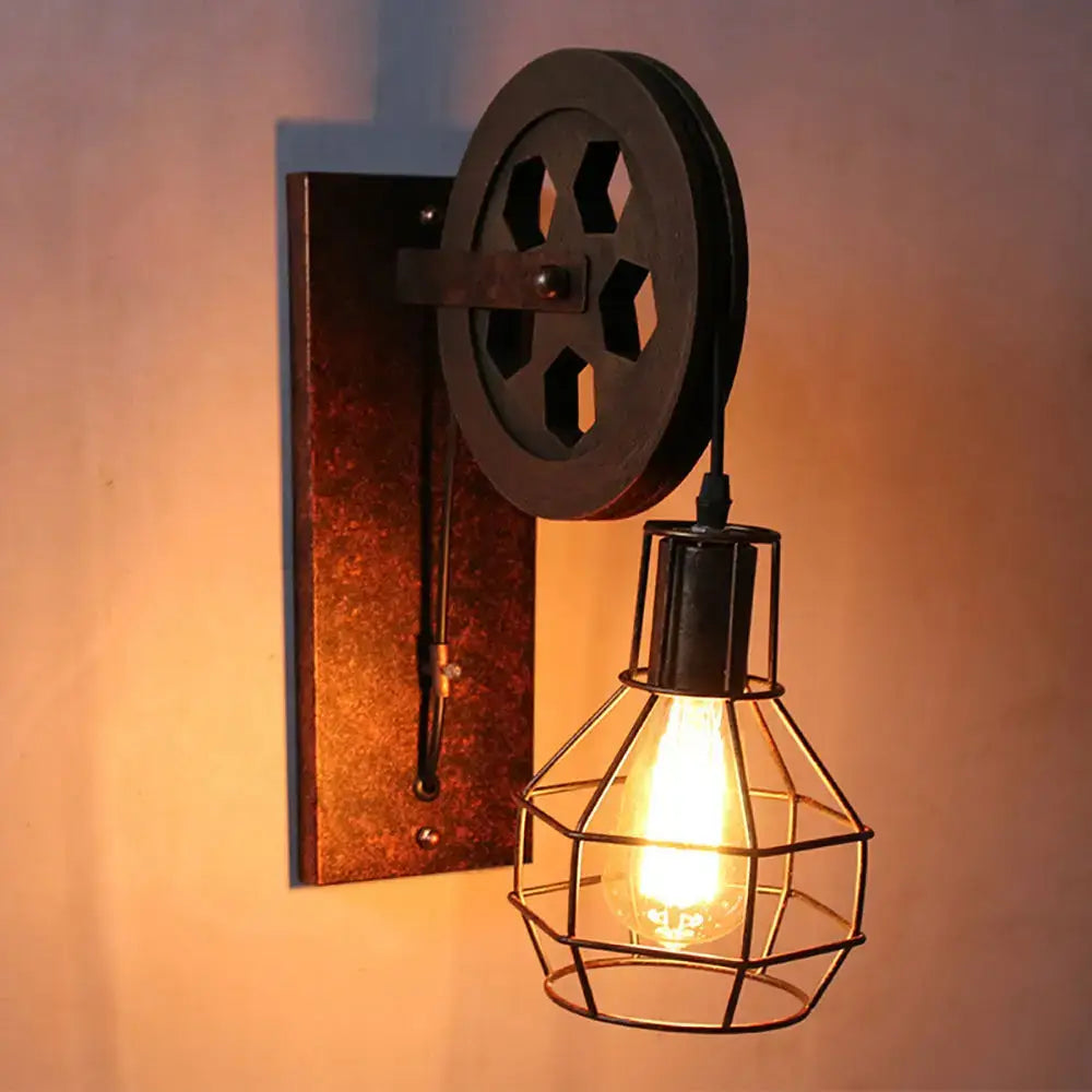Industrial iron wall sconce with dark metal pulley and cage design featuring exposed bulb for cafe decor by decorbites