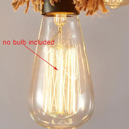 Clear glass Edison bulb with visible filament and black metal base hanging by natural rope in decorbites industrial loft chandelier