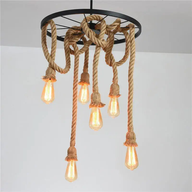 Industrial loft chandelier by decorbites features a black metal frame with natural brown rope and glowing edison bulbs for dining room decor