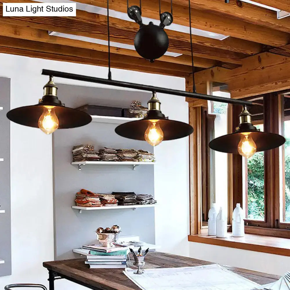 DecorBites™ industrial style metal island pendant light with black finish and chain cord featuring brass accents hangs indoors