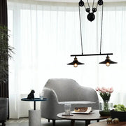Black mickey mouse-themed metal island pendant light with two exposed bulbs and chain cord pull mechanism for indoor use