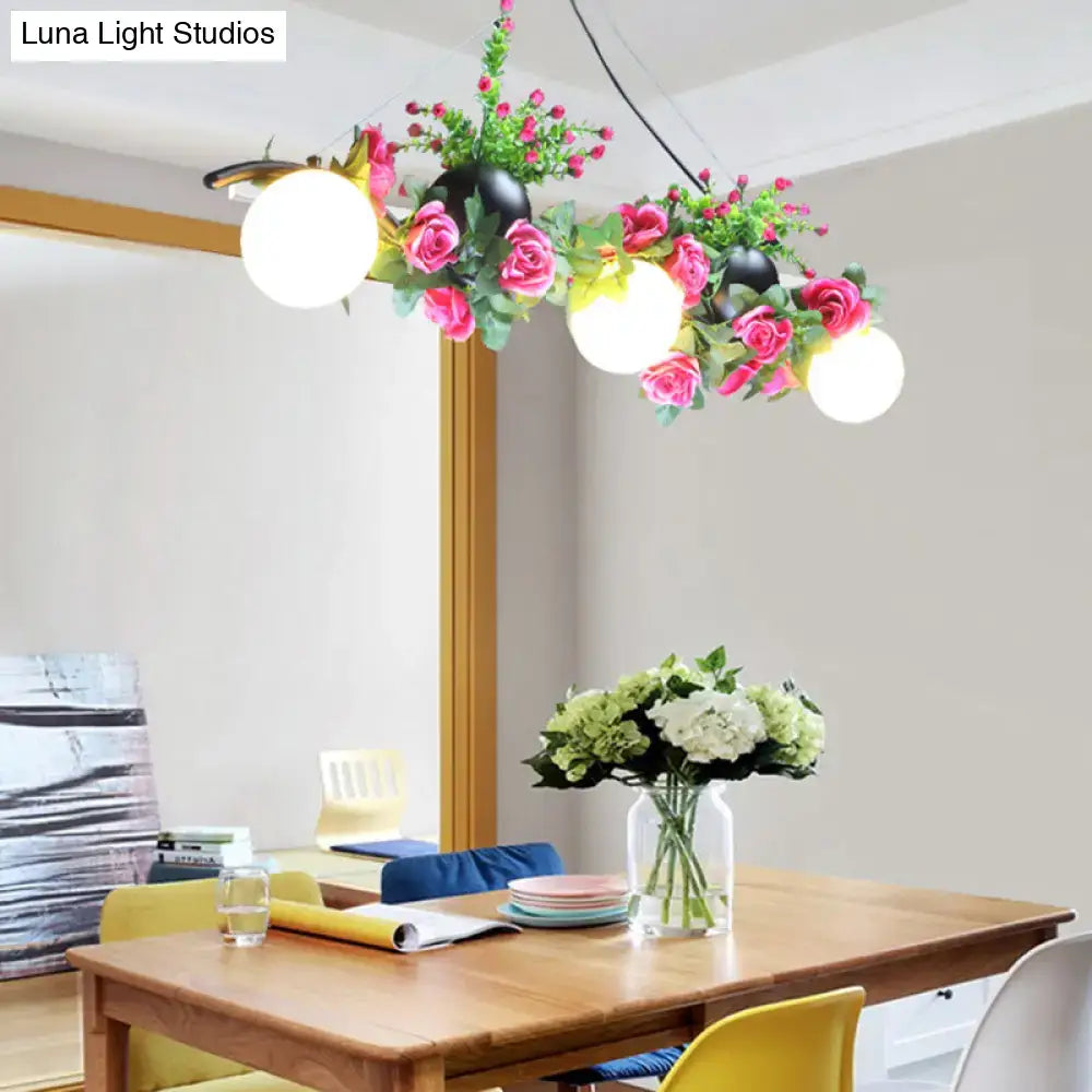 Decorbites industrial opal glass pendant light with three black flower heads and glowing bulbs above dining room island